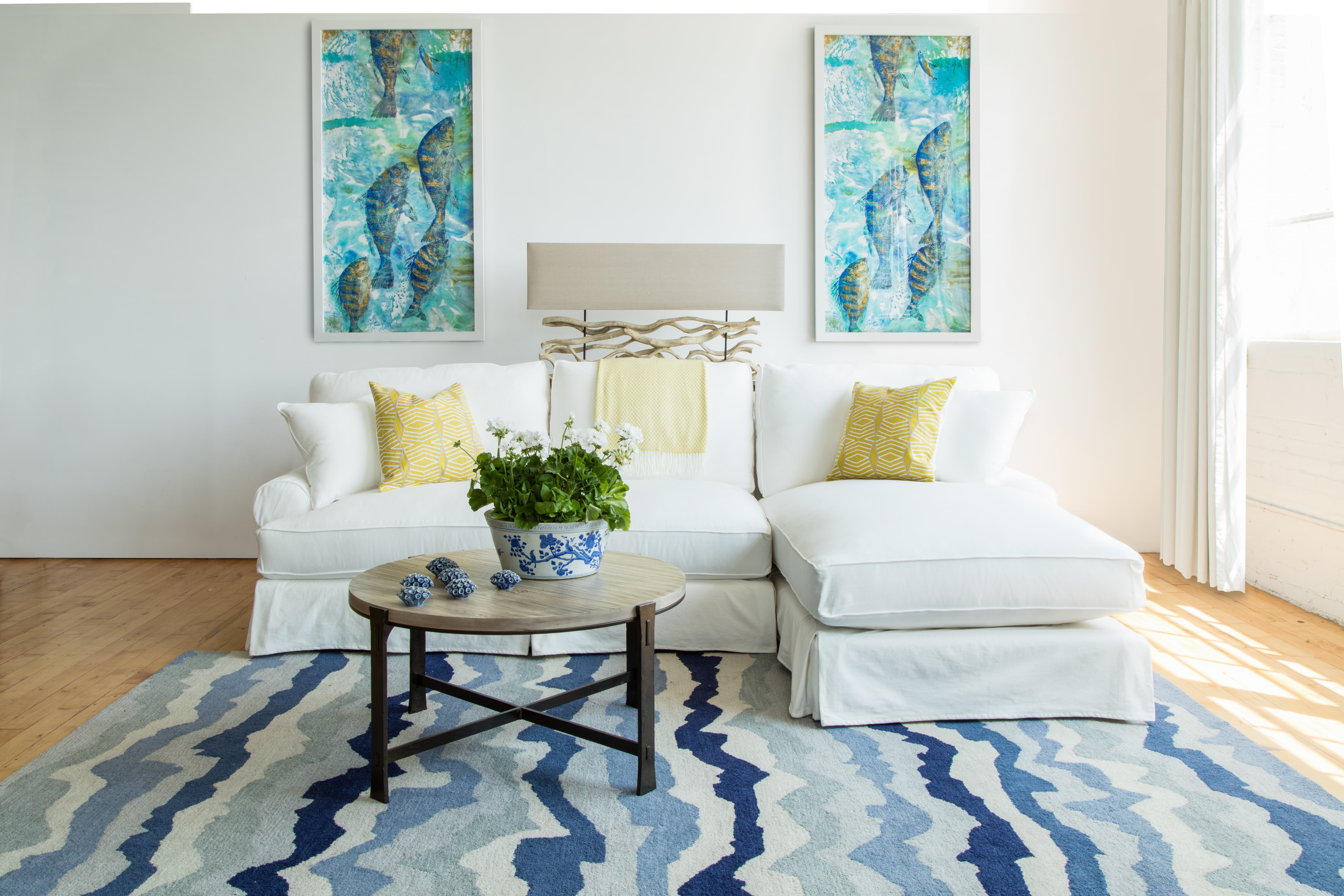 white sofa paired with an area rug featuring blue wavy stripes