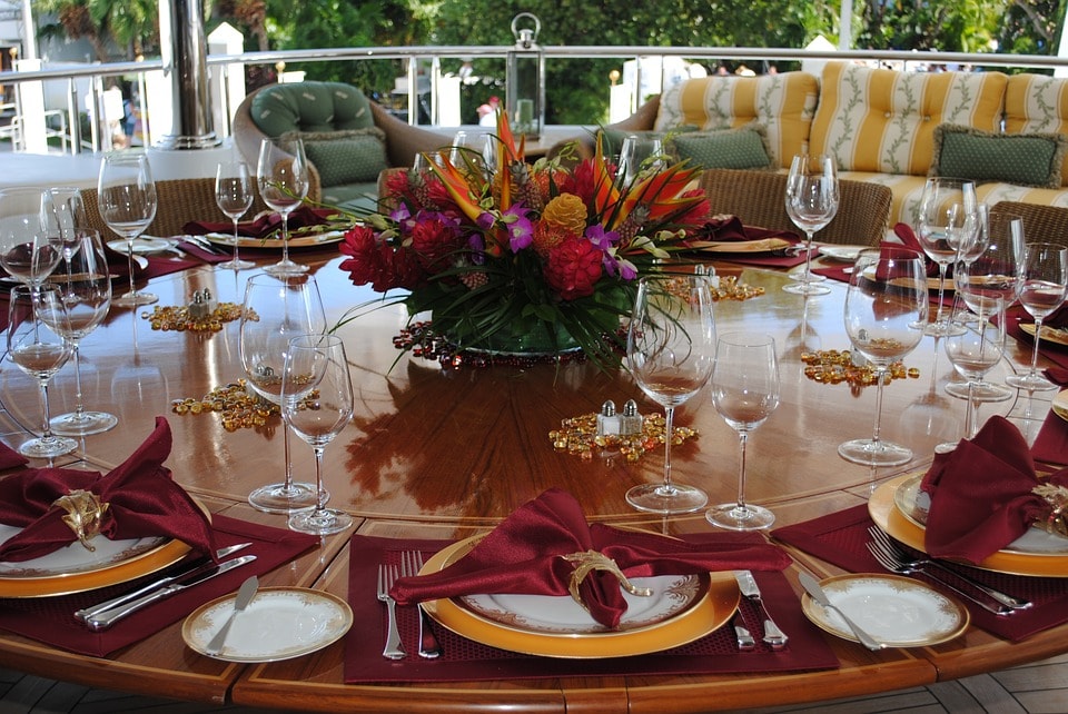 round glass table with wine glasses and table setting with fabric napkins