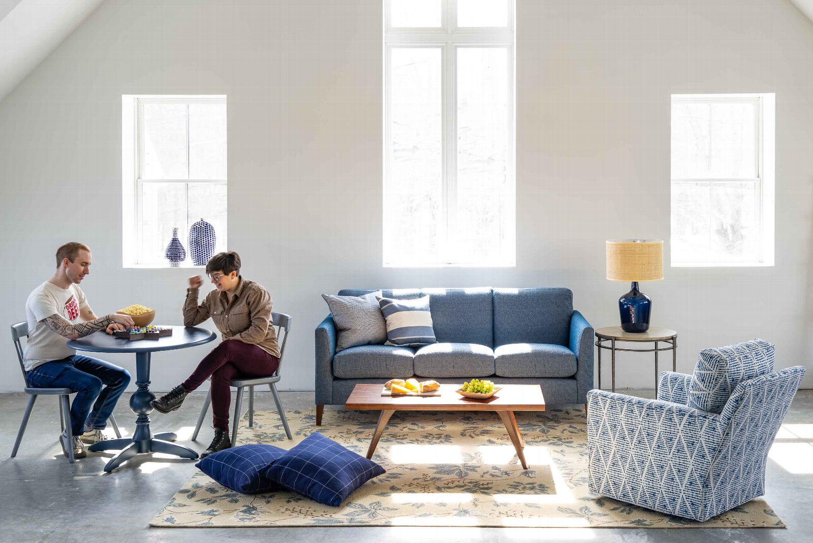 two people sitting at small table in living room