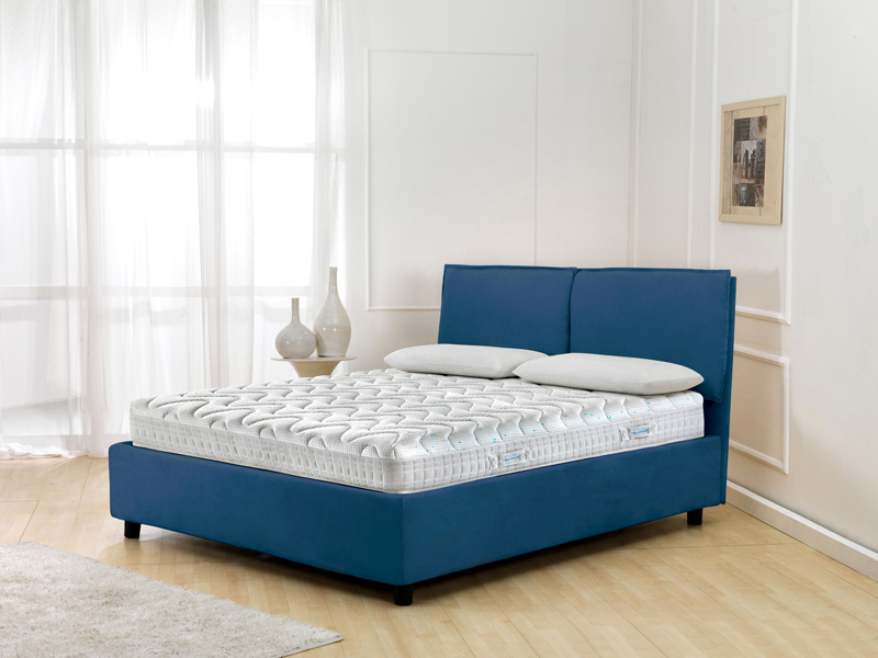 Magniflex MagniStretch mattress atop a blue upholstered bed